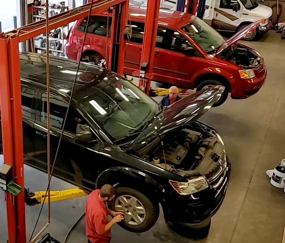 Technicians at work inside a busy independent auto service shop